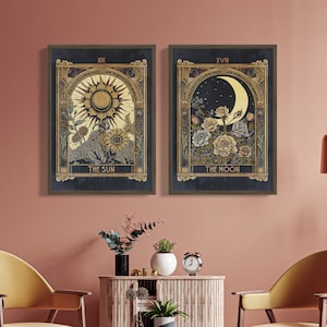 May include: Two framed tarot card prints, one depicting The Sun with a golden sun and sunflowers, and the other depicting The Moon with a crescent moon and flowers. Both prints have a dark blue background and gold accents.