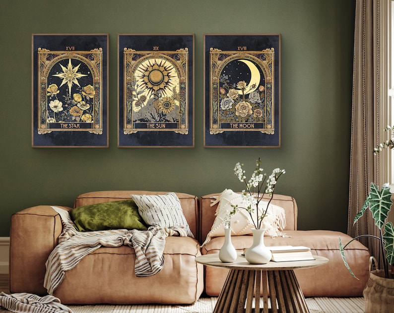 May include: Three framed prints with gold accents and a dark blue background. Each print features a different tarot card: The Star, The Sun, and The Moon. The cards are illustrated with flowers and celestial bodies.