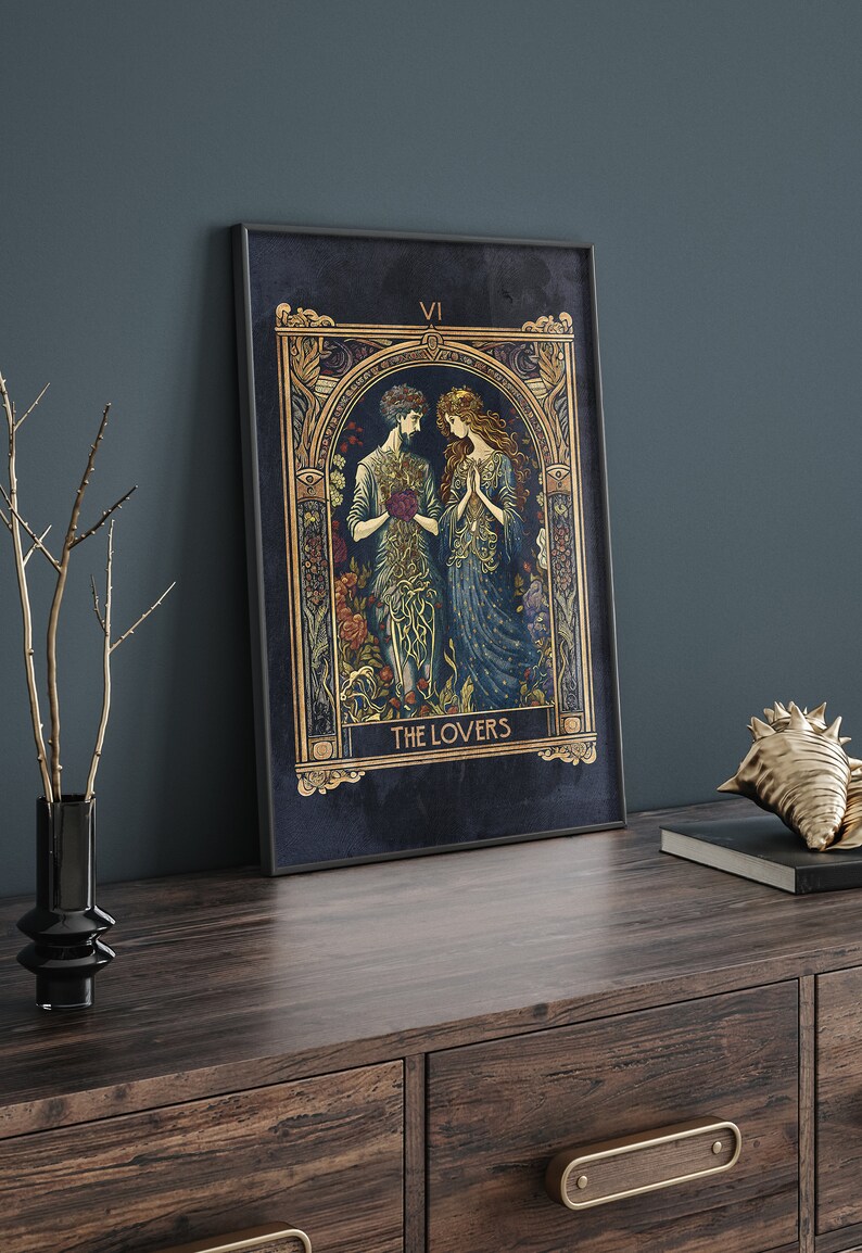 May include: A tarot card with a dark blue background and gold accents. The card depicts two figures, a man and a woman, standing together in a garden. The card is titled "The Lovers" and the Roman numeral "VI" is in the top right corner.