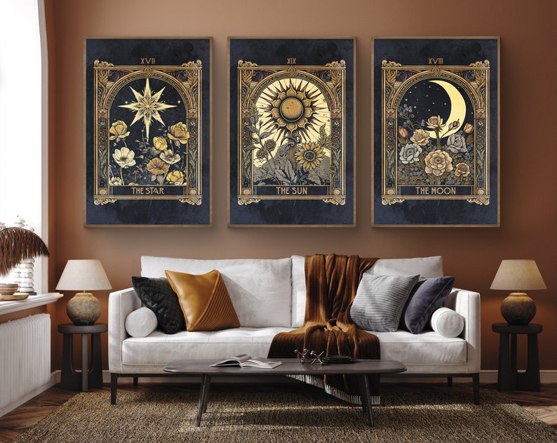 May include: Three framed prints with a dark blue background and gold accents. Each print features a celestial body, including a star, the sun, and the moon, surrounded by flowers. The text "The Star", "The Sun", and "The Moon" is printed below each image.