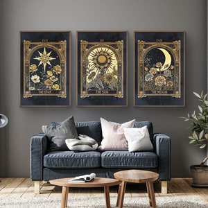 May include: Three framed prints with gold accents and a dark blue background. Each print features a celestial body, including a star, sun, and moon, with floral details. The prints are titled "The Star", "The Sun", and "The Moon".