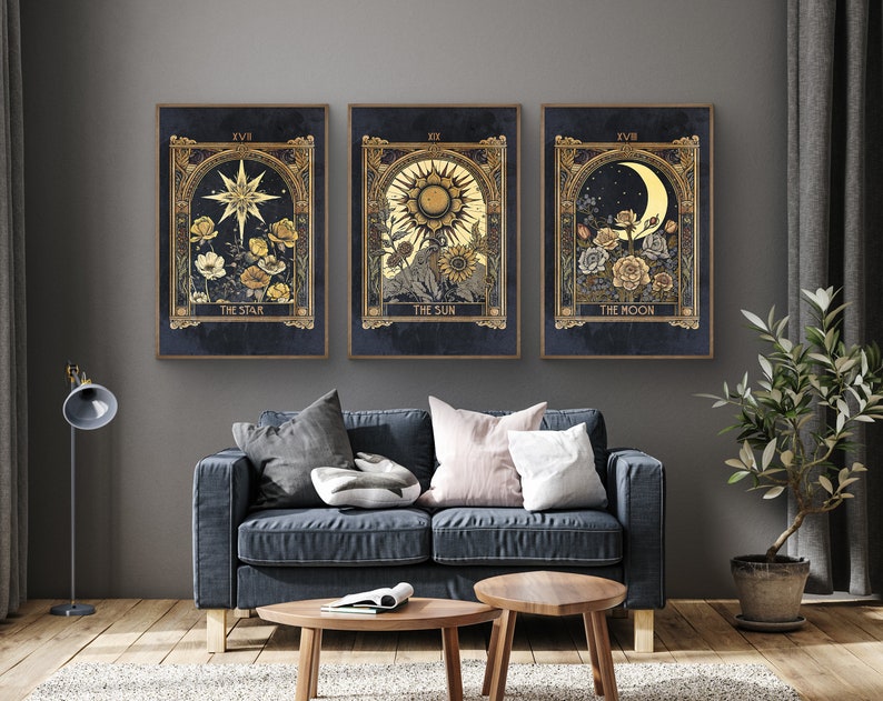 May include: Three framed prints with gold accents and a dark blue background. Each print features a celestial body, including a star, sun, and moon, with floral details. The prints are titled "The Star", "The Sun", and "The Moon".