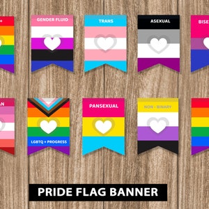 May include: A set of ten pride flag banners with different colors and designs. Each banner has a white heart in the center and the name of the flag printed at the top. The banners are arranged in two rows of five on a wooden background. The text at the bottom reads "PRIDE FLAG BANNER".
