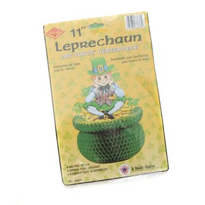 Könnte beinhalten: Ein 28 cm großes Leprechaun-Zentrumstück aus Seidenpapier für den St. Patrick's Day. Das Zentrumstück zeigt einen grünen Kobold, der auf einem Topf voller Gold sitzt. Die Verpackung enthält den Text "Art-Tissue Centerpiece" und "Decoration de Table pour St. Patrick".