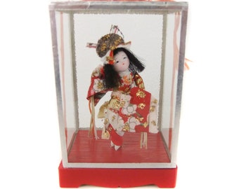 chinese doll in glass case