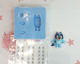 May include: A blue silicone mold with a cartoon animal design. The mold is for making polymer clay figures. The mold is 5.4mm in size. There is a sheet of white paper with multiple small circles on it. The circles are for making eyes for the clay figures. The paper sheet is labeled "Art Mary 5,4mm".