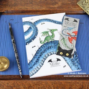 Blue Dragon Notebook featuring my original pen and ink dragon illustration, back cover, shown with bookmark and vintage Victorian writing desk accessories. Made in the UK. Design and illustration © Nicola L Robinson | Teeth and Claws