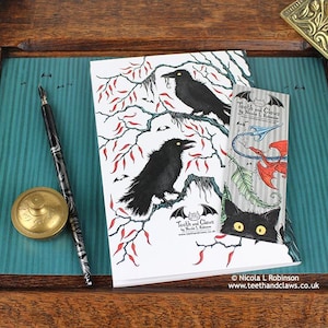 Gothic Crows Notebook featuring my original pen and ink crow illustration, back cover, shown with bookmark and vintage Victorian writing desk accessories. Made in the UK. Design and illustration © Nicola L Robinson | Teeth and Claws