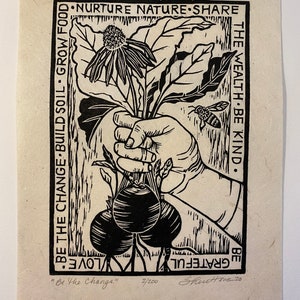 May include: Black and white woodcut print of a hand holding a bouquet of flowers and two beets. The text reads "Be the Change: Build Soil, Grow Food, Nurture Nature, Share the Wealth, Be Kind. Be Grateful. Love."