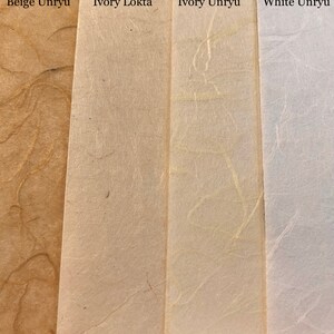 May include: Four samples of paper, from left to right: Beige Unryu, Ivory Lokta, Ivory Unryu, and White Unryu. The paper is textured and has a natural, handmade look.
