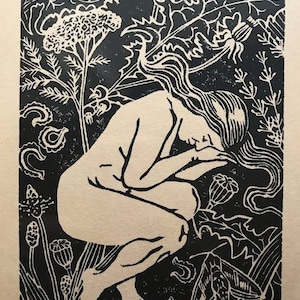May include: Black and white woodcut print of a nude figure with long hair, curled up in a fetal position, surrounded by stylized plants. The print is titled "medicine" and numbered 2/50.