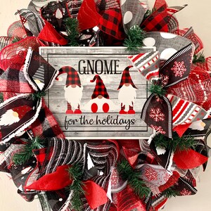 May include: A Christmas wreath with red, black, and white plaid ribbon, gray and white polka dot ribbon, and a sign that reads "Gnome for the holidays".