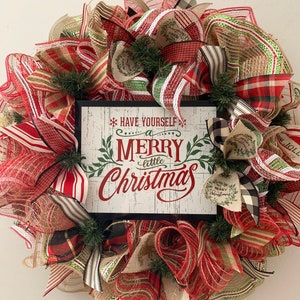 May include: A red, green, and white Christmas wreath with a sign that reads "Have Yourself a Merry Little Christmas".
