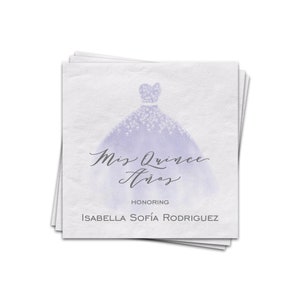 May include: A stack of white napkins with a purple watercolor illustration of a quinceañera dress. The text "Mis Quince Años" is written in cursive script. The text "Honoring Isabella Sofía Rodriguez" is printed below the illustration.