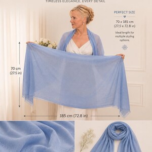 Puede incluir: Un chal pashmina de color azul polvoriento con bordes deshilachados. La envoltura rectangular mide 70 cm por 185 cm. La tela tiene una textura suave y ligera. El texto en la imagen dice DUSTY BLUE PASHMINA, TIMELESS ELEGANCE, EVERY DETAIL.