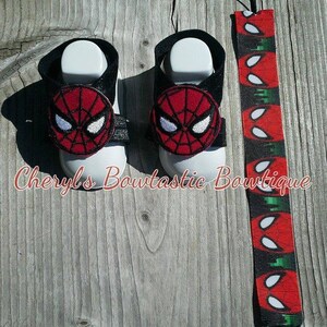 May include: A pair of baby sandals with a black strap and a red and black Spider-Man applique. A matching red, black, and white Spider-Man themed pacifier clip is also included.