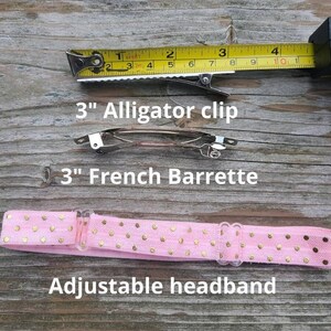 May include: A pink headband with gold polka dots and an adjustable plastic clasp. The headband is shown with two hair clips: a 7.6 cm alligator clip and a 7.6 cm French barrette.