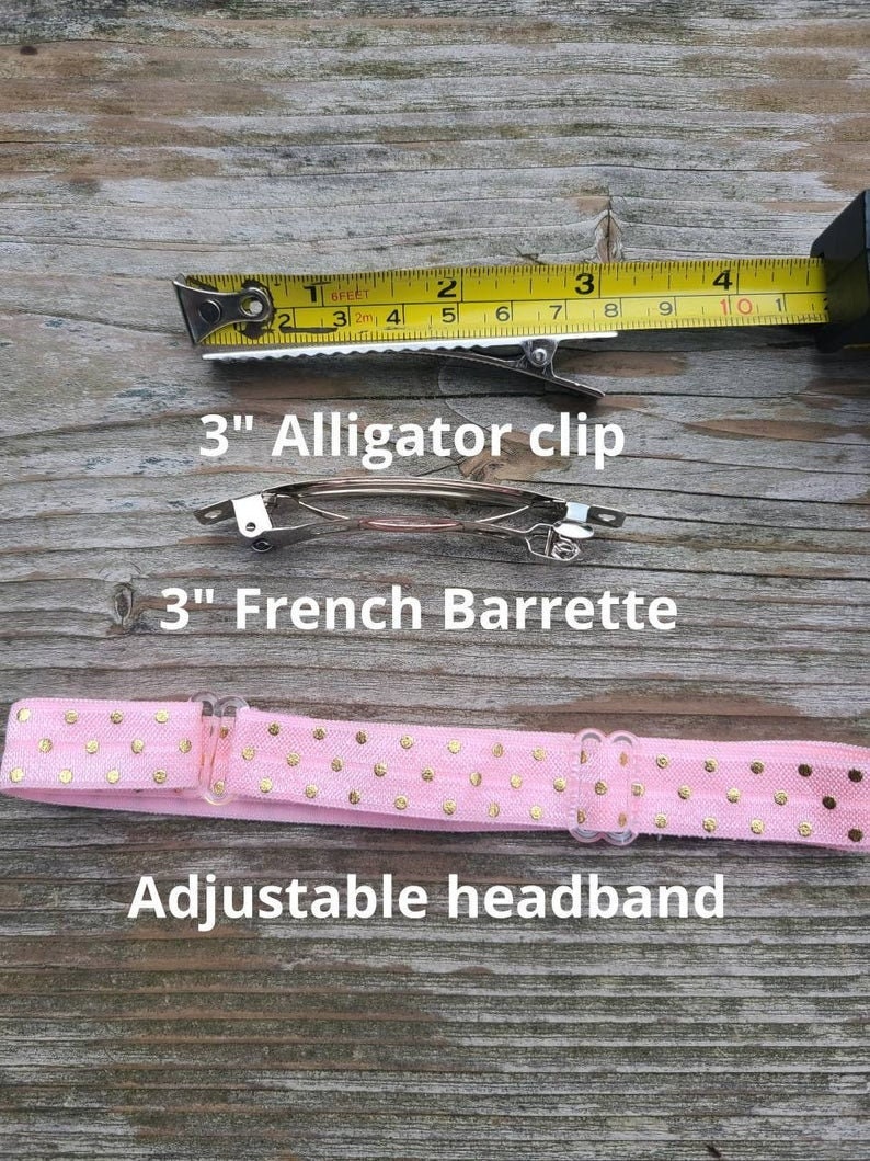 May include: A pink headband with gold polka dots and an adjustable plastic clasp. The headband is shown with two hair clips: a 7.6 cm alligator clip and a 7.6 cm French barrette.
