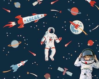 Pode incluir: Uma parede azul com adesivos de parede com tema espacial. Os adesivos incluem um foguete, um astronauta, planetas, estrelas e estrelas cadentes. O texto "LUCAS" está no foguete.