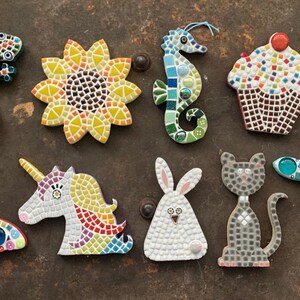 May include: A collection of ten mosaic tile ornaments featuring various animal and nature designs. The ornaments include a butterfly, a unicorn, a rabbit, a cat, a dragonfly, a sunflower, a seahorse, a lizard, and a cupcake.