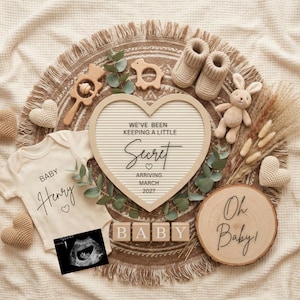 May include: A neutral-toned baby announcement with a heart-shaped letter board that reads "We've been keeping a little secret, arriving March 2027." Includes a onesie with "Baby Henry" and a sonogram, surrounded by baby shoes, toys, and wooden blocks.