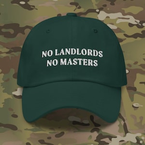 May include: A dark green baseball cap with white embroidered text that reads "NO LANDLORDS NO MASTERS".