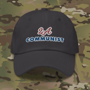 Pode incluir: Um boné de beisebol preto com um logotipo bordado em vermelho e azul que diz "2A COMMUNIST".