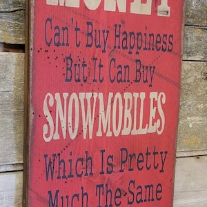 Met geld kun je geen geluk kopen, maar je kunt er wel sneeuwscooters mee kopen, wat vrijwel hetzelfde is, humoristisch, westers, antiek, houten bord
