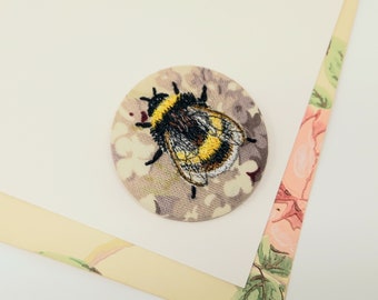Embroidered bumble bee brooch.