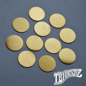 May include: Ten round, brass discs of various sizes on a gray background.