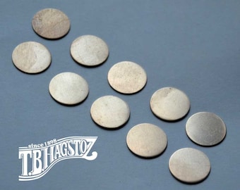 May include: Ten silver-colored metal discs arranged in a staggered pattern on a light blue surface.