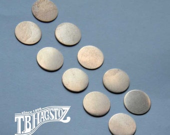 May include: Ten silver-colored metal discs of various sizes arranged in a diagonal line on a light blue background.