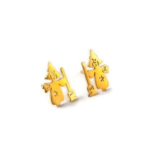Könnte beinhalten: Ein Paar goldfarbene Ohrringe mit einer Silhouette einer Hexe, die einen Besen hält.