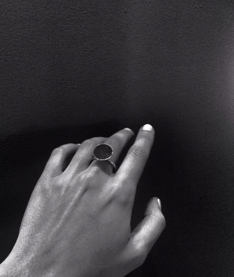May include: A silver ring with a large, round, black stone.