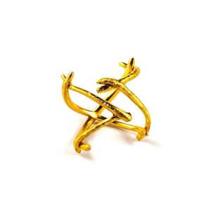 May include: A gold-colored metal ring with a twisted, branch-like design.