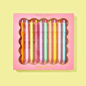 May include: A set of ten colorful gel pens in a pink box. Each pen is a different pastel color and has an inspirational phrase printed on it. The box is labeled "Taylor Elliott Designs" and "Colored Ink Gel Pens."