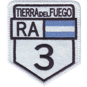 May include: White embroidered patch with black text and a blue and white stripe. The text reads "Tierra del Fuego RA 3".