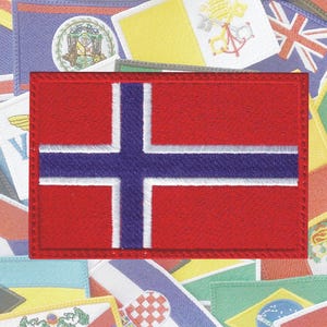 May include: A red, white, and blue embroidered patch featuring the flag of Norway. The patch is surrounded by other flags.