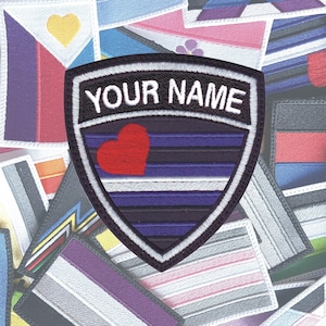 May include: A black and white embroidered patch with a heart and stripes in the center. The patch is shaped like a shield and has the text "YOUR NAME" at the top. The patch is surrounded by a variety of colorful embroidered patches.