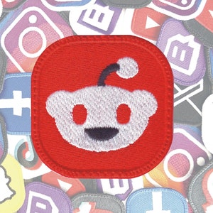 May include: A red embroidered patch with a white Reddit alien logo. The alien has a single antenna and a friendly smile.