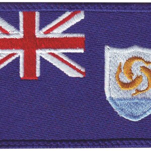 May include: A blue flag with a red, white, and blue Union Jack in the upper left corner and a white shield with a gold symbol in the lower right corner.