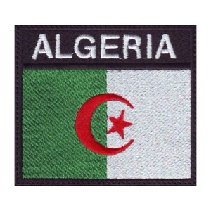 May include: An embroidered patch with the Algerian flag. The flag is green, white, and red with a crescent moon and star in the center. The patch has a black border and the word "ALGERIA" in white letters at the top.