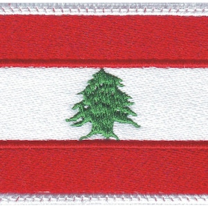 May include: A red, white, and green embroidered patch featuring the flag of Lebanon. The flag has a white horizontal stripe in the center with a green cedar tree on it. The top and bottom stripes are red.