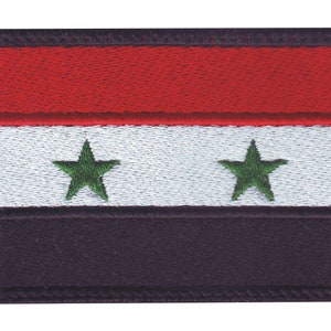 May include: A red, white, and black embroidered patch with two green stars. The patch is a representation of the Syrian flag.