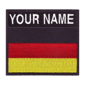 May include: Black and white embroidered patch with the text "YOUR NAME" above the German flag. The flag is red, yellow, and black.