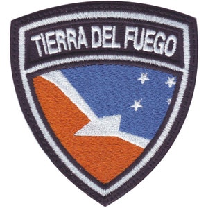 May include: A black and white embroidered patch with a blue and orange flag and the text "TIERRA DEL FUEGO" in white.
