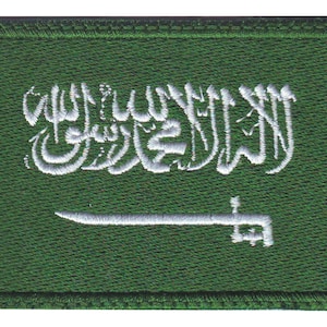 May include: Green embroidered patch with the white Arabic script of the Shahada and a white sword, representing the flag of Saudi Arabia.