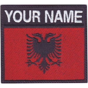 May include: An embroidered patch featuring the Albanian flag in red and black, with the text "YOUR NAME" in white.