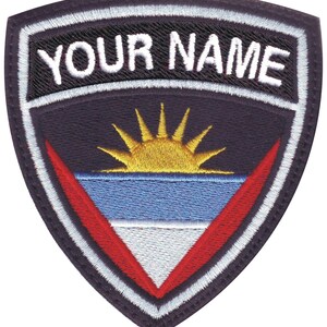 May include: Embroidered patch with a navy blue background, white border, and the text "YOUR NAME" in white. The center features the flag of Antigua and Barbuda, with a yellow sun rising over blue and white stripes.