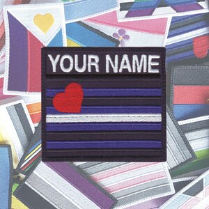 May include: A purple and white striped patch with a red heart and the text "YOUR NAME" in white. The patch is surrounded by other colourful patches.